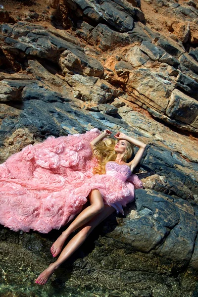 Hermosa modelo rubia femenina con un cuerpo perfecto y cabello largo increíble en la isla de Santorini en Grecia y alrededor de ella es increíble vista — Foto de Stock