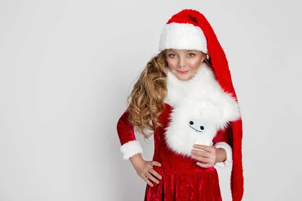 Krásná holčička s ohromující dlouhé blond, oblečený v obleku Santa Clause radostně Podívejte se do objektivu v době Vánoc — Stock fotografie