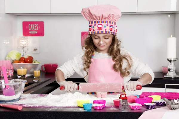 Menina engraçada bonita filha criança em aventais cozinha cozinhar na cozinha biscoitos e macarrão e bolos — Fotografia de Stock