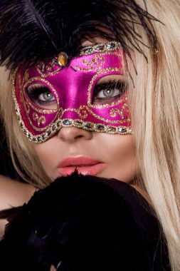 Güzel seksi sarışın kadın karnaval maskesi, siyah balon ve seksi bir arka plan üzerinde duran lense benziyor.