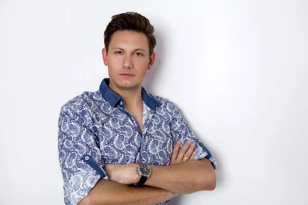 Beyaz bir arka plan üzerinde elinde bir saati olan iş elbiseli, zarif adam