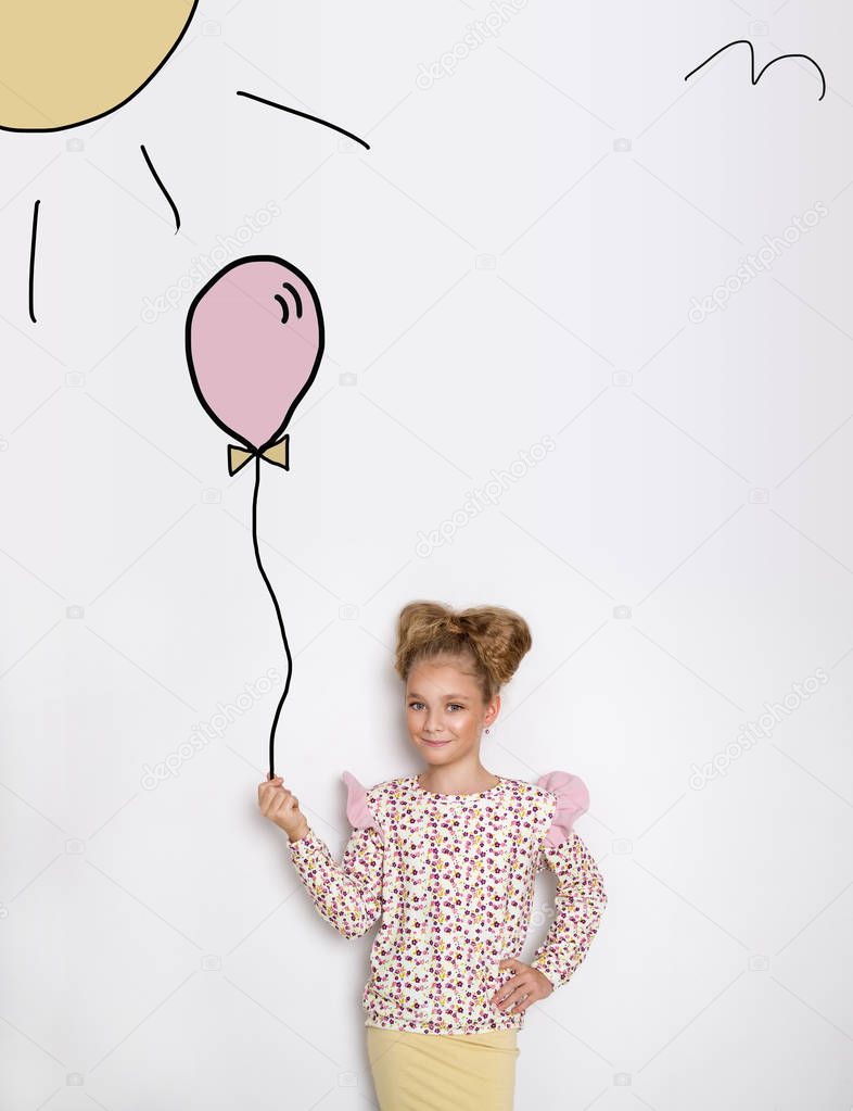 Stunning beautiful little girl with long blond hair standing on a white background and holds a balloon and flowers in his hand