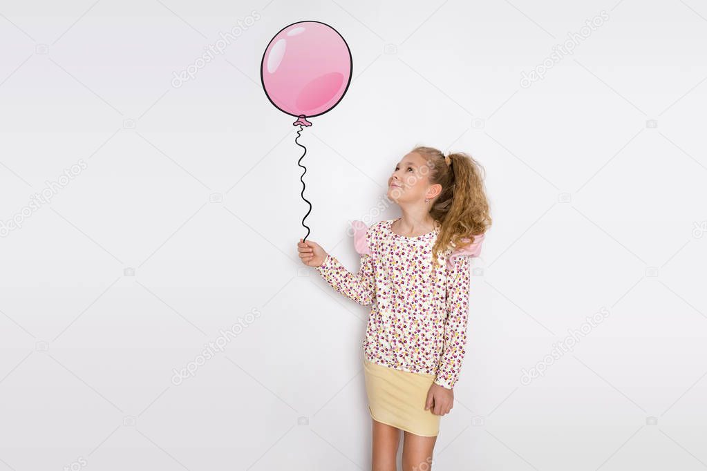 Stunning beautiful little girl with long blond hair standing on a white background and holds a balloon in his hand