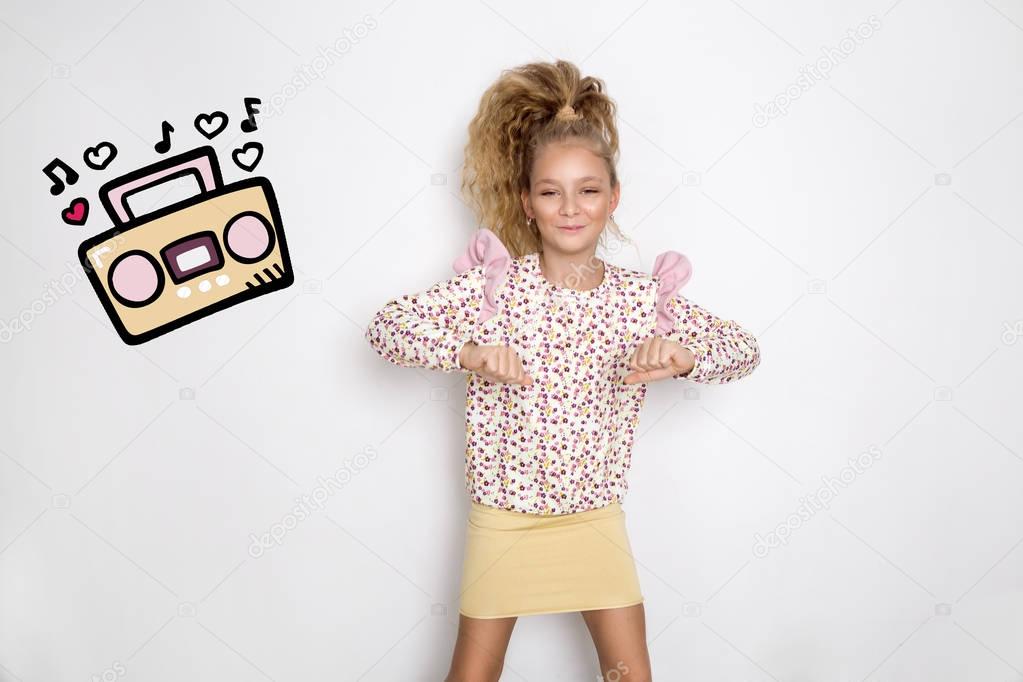 Stunning beautiful little girl with long blond hair standing on a white background and dancing to music from a cassette