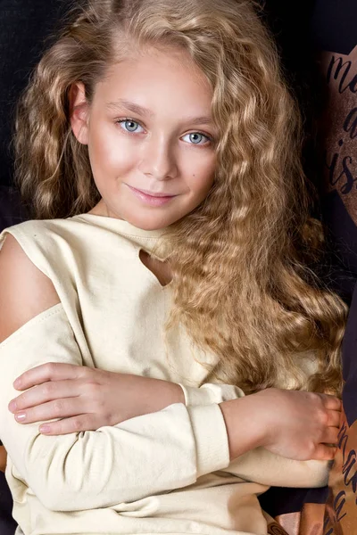 Nazik bir genç kız şaşırtıcı gözleri ve sarışın saç yalan yatakta ve arka planda siyah altın yastık bir yıldız küçüktür