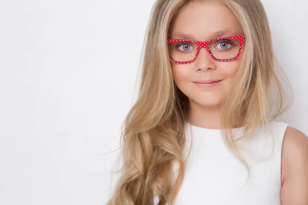 Menina bonito em um vestido de comunhão branca, de pé sobre um fundo rosa — Fotografia de Stock