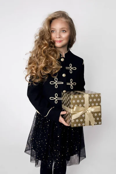 Stunning beautiful little girl with long blond hair holds in her hands gifts, joyfully look into the lens at Christmas time — Stock Photo, Image