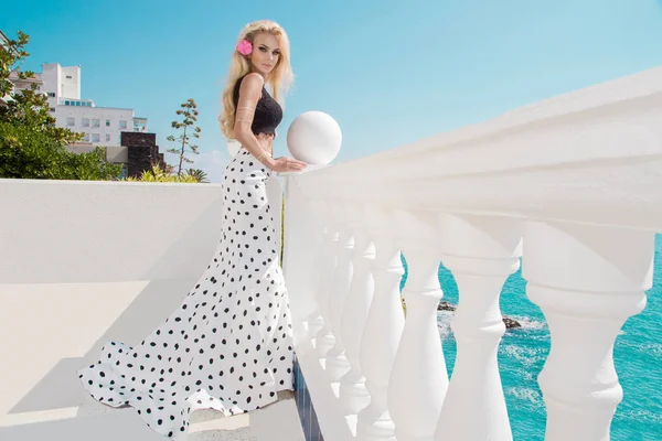 サントリーニ島の長いウェディング ドレスで排他的なプールの横にある美しい金髪女性モデル立ち — ストック写真