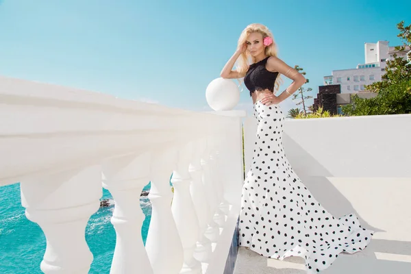 Vacker blond kvinnlig modell står bredvid en exklusiv pool i en lång brudklänning i ön Santorini — Stockfoto