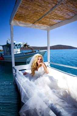 Santorini Adası Yunanistan üzerinde şaşırtıcı gelinlikle güzel gelin sarışın kadın model teşkil etmektedir ve ötesinde bu kadar güzel bir manzara