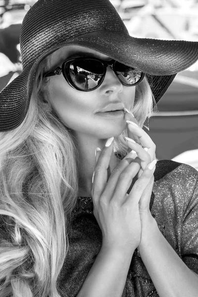 Λευκό πορτρέτο του το όμορφο μαύρο κομψό πολυτελές σέξι ξανθιά μοντέλο φοράει ένα καπέλο και γυαλιά ηλίου που στέκεται σε ένα γιοτ, Κάννες, Γαλλία — Φωτογραφία Αρχείου