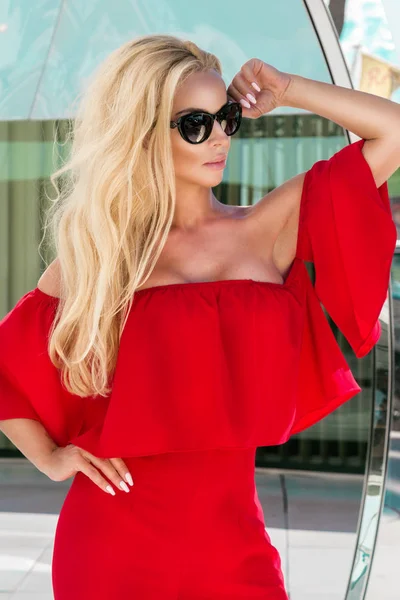 Vacker elegant kvinnligt mode modell i röd klänning stående framför lyxhotell och boutiquer i Cannes, Frankrike — Stockfoto