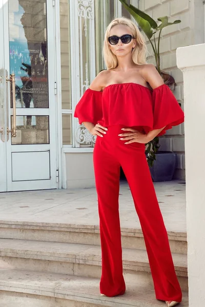 Hermosa modelo de moda femenina elegante en vestido rojo de pie frente a los hoteles de lujo y boutiques en Cannes, Francia —  Fotos de Stock