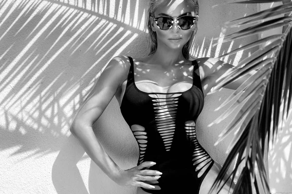 Palmiye ağacı gölge Fransa'nın Cannes şaşırtıcı görünümle zarif erotik Mayo ile güzel olağanüstü çarpıcı zarif seksi sarışın model kadın mükemmel yüz bir güneş gözlüğü takmış durumda