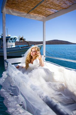 Santorini Adası Yunanistan üzerinde şaşırtıcı gelinlikle güzel gelin sarışın kadın model teşkil etmektedir ve ötesinde bu kadar güzel bir manzara