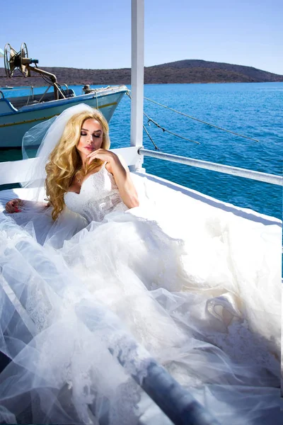 Santorini Adası Yunanistan üzerinde şaşırtıcı gelinlikle güzel gelin sarışın kadın model teşkil etmektedir ve ötesinde bu kadar güzel bir manzara