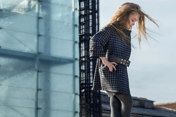 Genç sarışın kız güzel bir ceket ve çocuk moda için poz botlar giyim