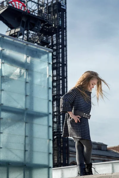 Genç sarışın kız güzel bir ceket ve çocuk moda için poz botlar giyim