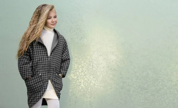 Красива молода блондинка в пальто і чоботи позують для моди, дитячий одяг — стокове фото