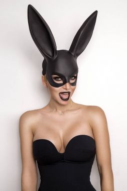 Bir Siyah giymeyi büyük memeli seksi kadınlar Paskalya bunny ayakta beyaz bir arka plan üzerinde maske ve çok sensually görünüyor