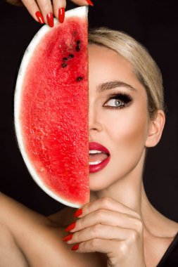 Güzel kadın modeli ile mükemmel yüz ve pürüzsüz bir cilt bakımı, holding ve karpuz meyve yeme