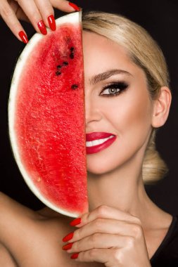 Güzel kadın modeli ile mükemmel yüz ve pürüzsüz bir cilt bakımı, holding ve karpuz meyve yeme