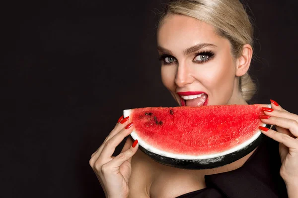 Hermoso modelo femenino con cara perfecta y cuidado suave de la piel, sosteniendo y comiendo fruta de sandía — Foto de Stock