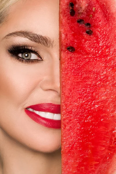 Modelo feminino bonito com rosto perfeito e cuidados com a pele lisa, segurando e comendo frutas de melancia — Fotografia de Stock