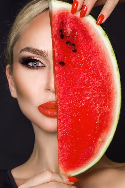 Modelo feminino bonito com rosto perfeito e cuidados com a pele lisa, segurando e comendo frutas de melancia — Fotografia de Stock