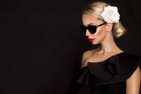 Ritratto di bella donna con splendido viso con fiore in capelli e in elegante make-up, su sfondo nero — Foto Stock
