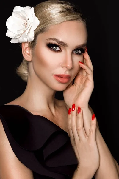 Ritratto di bella donna con splendido viso con fiore in capelli e in elegante make-up, su sfondo nero — Foto Stock