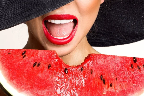 Mükemmel yüz ve kırmızı şapka bir karpuz yüzüne holding ile güzel kadın modeli