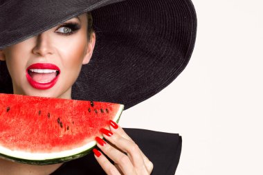 Mükemmel yüz ve kırmızı şapka bir karpuz yüzüne holding ile güzel kadın modeli