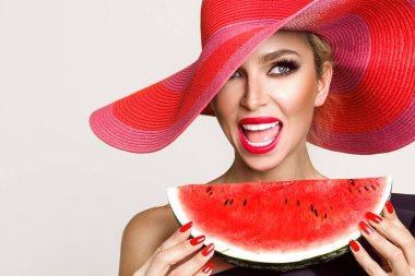 Mükemmel yüz ve kırmızı şapka bir karpuz yüzüne holding ile güzel kadın modeli