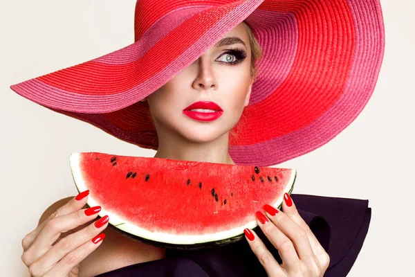 完璧な顔と彼女の顔で、スイカを押し赤い帽子と美しい女性モデル — ストック写真