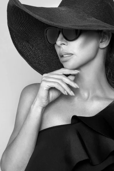 Portrét ženy elegantní klobouk a sluneční brýle na béžové pozadí — Stock fotografie