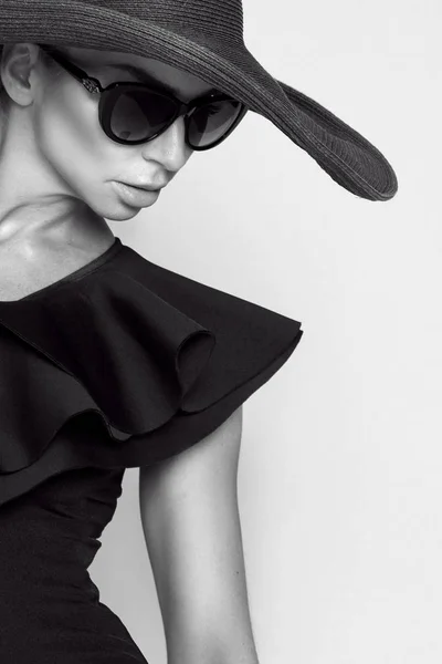 Retrato de una mujer elegante con sombrero y gafas de sol sobre fondo beige — Foto de Stock