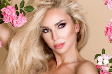 Gül çevrede uzun sarı saçlı güzel, gülümseyen kadın portresi