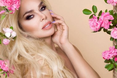 Gül çevrede uzun sarı saçlı güzel, gülümseyen kadın portresi