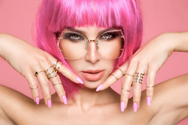 Hermosa modelo en peluca rosa y maquillaje de color con uñas de colores largos —  Fotos de Stock