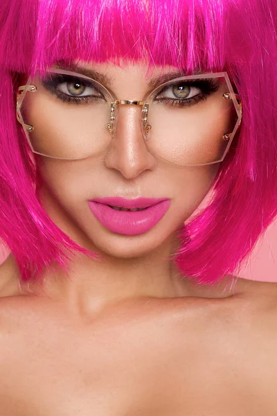 Modelo bonito em peruca rosa e maquiagem colorida com unhas coloridas longas — Fotografia de Stock