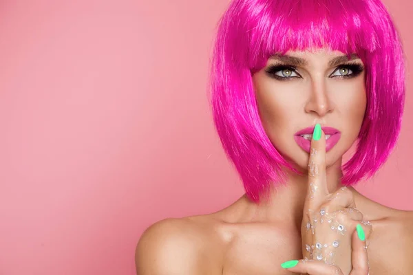 Bellissimo modello in parrucca rosa e trucco colorato con unghie lunghe colorate — Foto Stock