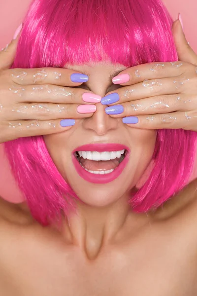 Gyönyörű modell a rózsaszín paróka és színes smink és hosszú színes körmök — Stock Fotó