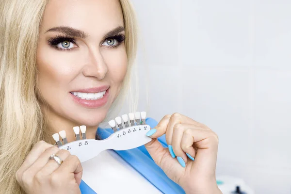 Beyaz ve sağlıklı dişlere sahip güzel ve genç kadın, o gülümsüyor. Onda sağlıklı ve beyazlatılmış diş ve porselen kaplama.