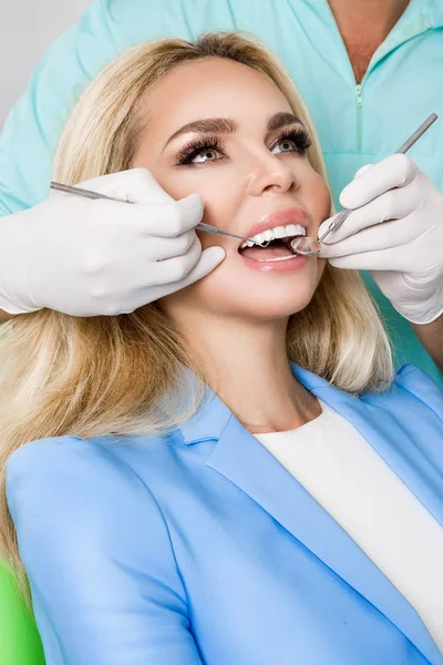 치과 자에 앉아 아름 다운 흰 이빨을 가진 젊은 아름 다운 여자. 그녀의 이빨을 치료 하는 치과. — 스톡 사진
