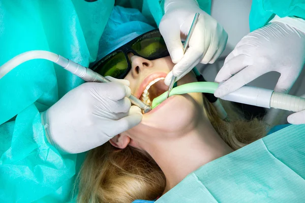 Genç güzel kadın güzel beyaz dişleri diş bir sandalyede oturuyor. Diş hekimi diş tedavileri. — Stok fotoğraf