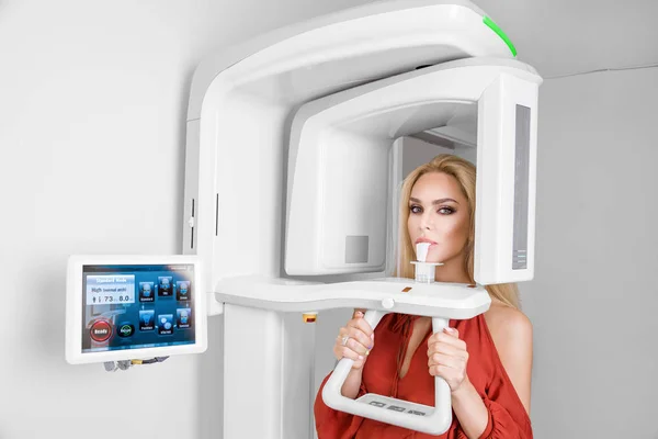 Güzel beyaz dişlere sahip genç güzel kadın dişçide olduğunu. Diş hekimi diş röntgen yapıyor.