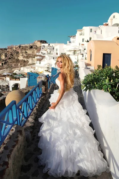 Hermosa novia, modelo rubia en vestido de novia increíble corre a Santorini en Grecia. Esposa huyendo —  Fotos de Stock