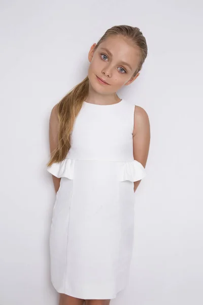 美しいの金髪の若いモデル、かわいい女の子は、白い背景に白いドレス。エレガントな女の子 — ストック写真