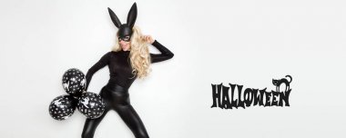 Beyaz arka plan üzerinde duran ve balonlar tutan bunny kostüm, güzel genç kadın